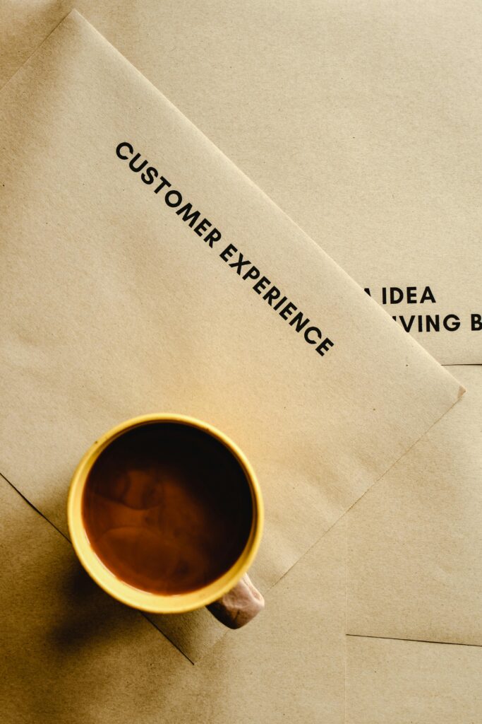 Aesthetic flat lay of a coffee cup on brown envelopes with text, highlighting customer experience.